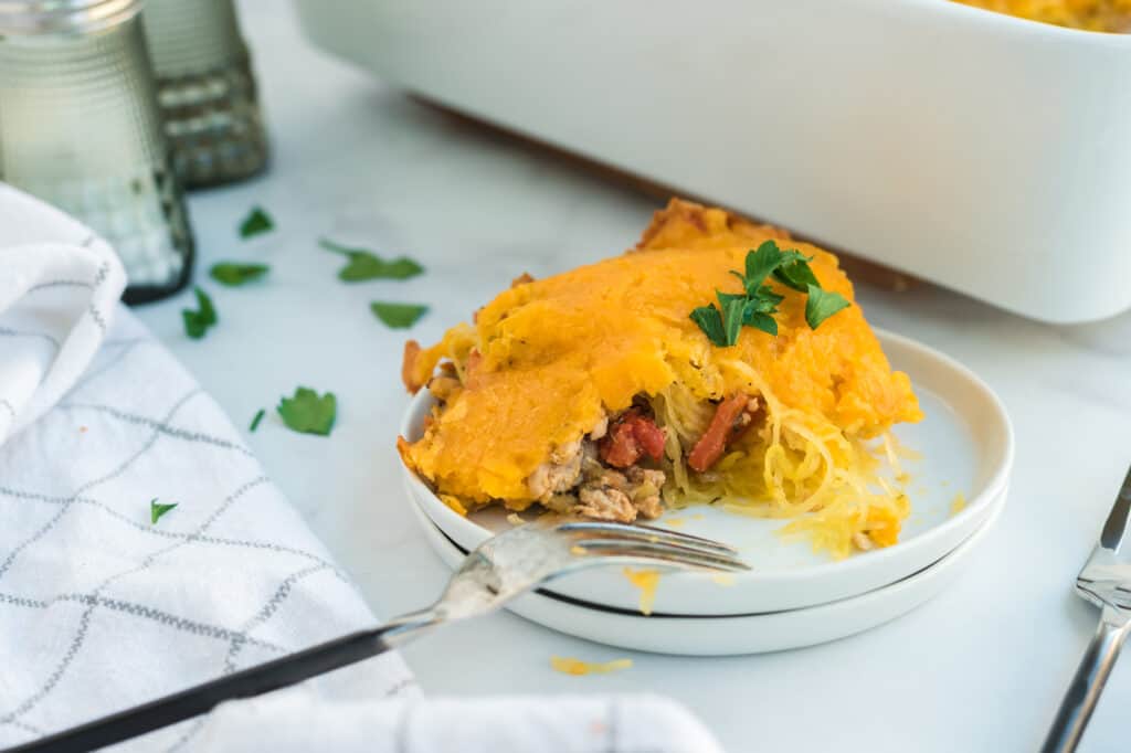 one serving of casserole on a stack of white plates