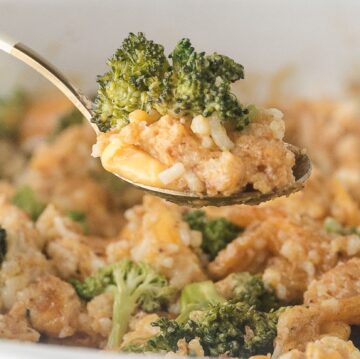 Spoon holding up a serving of broccoli cheese and rice casserole
