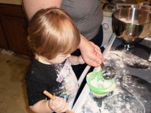 a little girl measuring flour and water