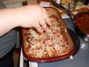 cheese on top of the meat sauce in the lasagna pan