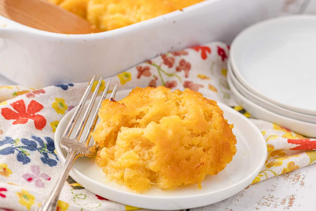 pineapple casserole on a white plate with a fork