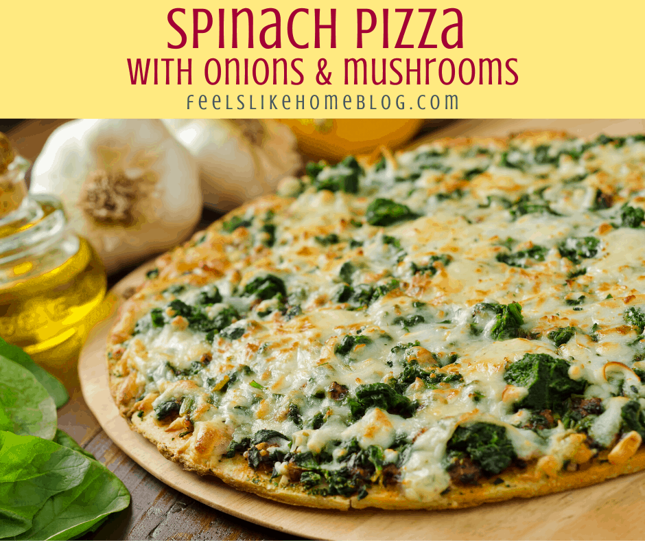 a pizza with spinach, onions, and mushrooms