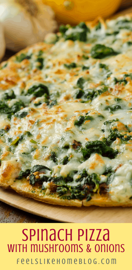 close up of spinach pizza with onions and mushrooms and cheese