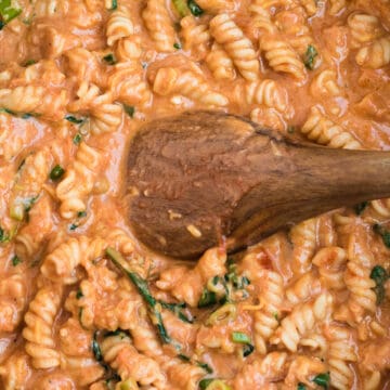 pasta in red sauce with a wooden spoon
