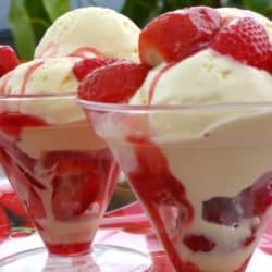 A dessert in a glass cup on a table, with Ice cream