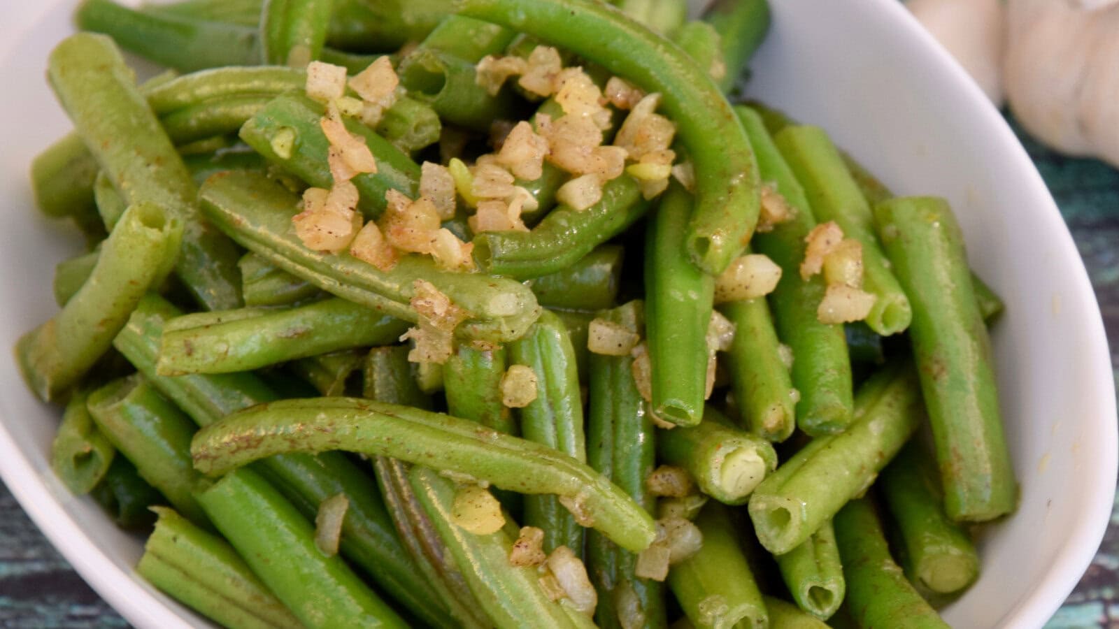 green beans with caramelized onions in a white bowl