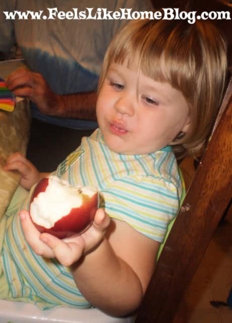 A little girl eating an apple