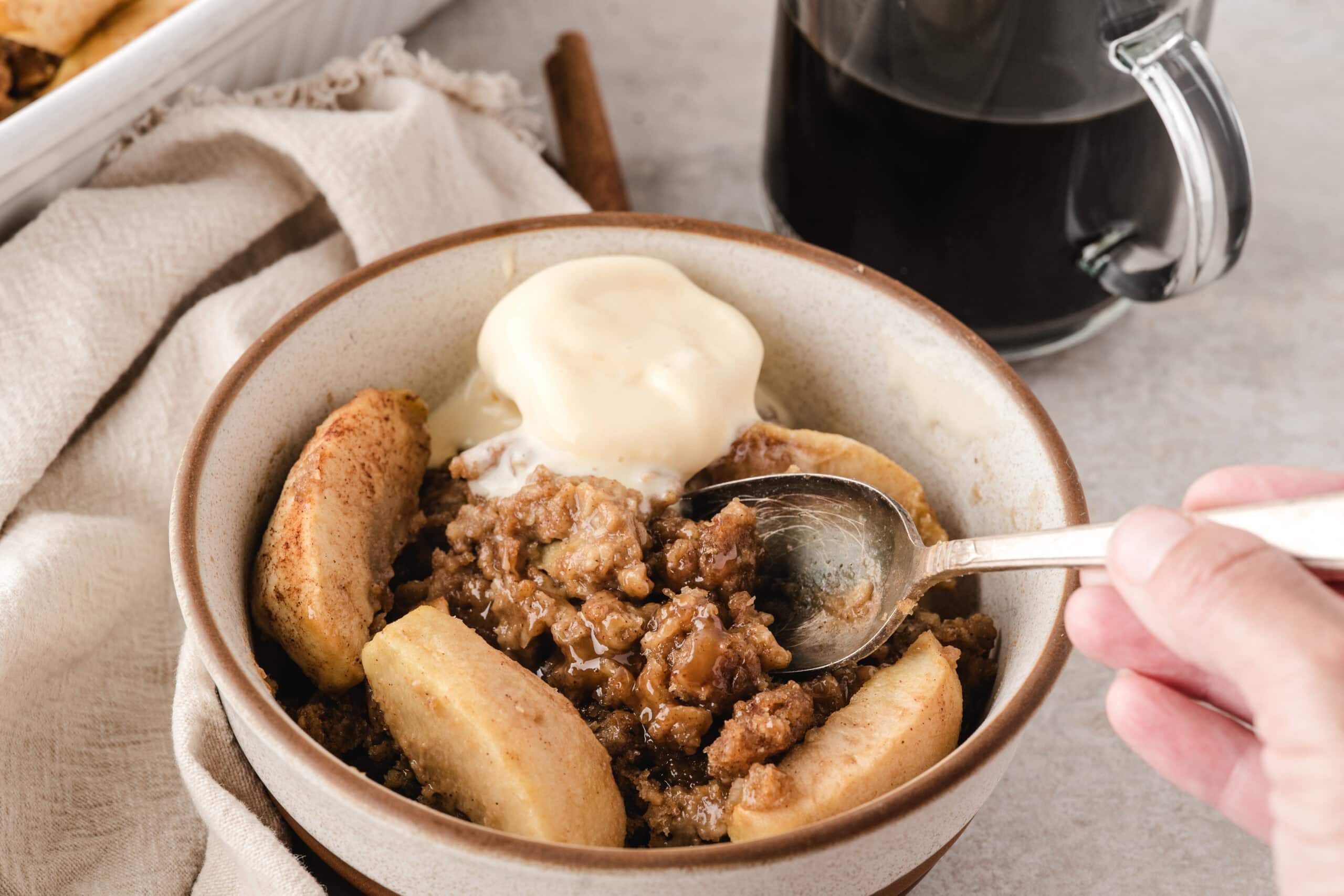 easy apple crisp baked and served in a bowl with vanilla ice cream