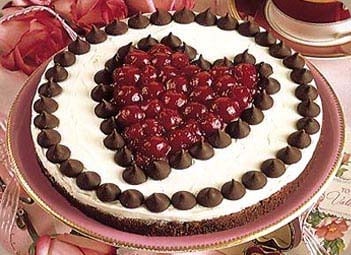 a brownie cheesecake with Hershey\'s kisses and cherries on top