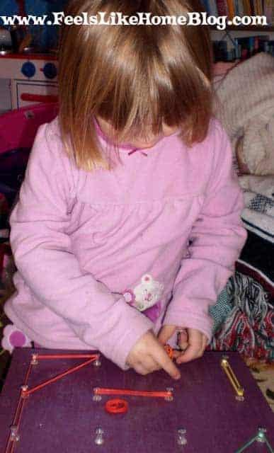 A little girl using her geoboard