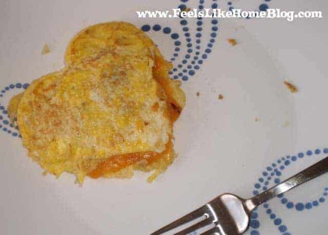 A heart shaped omelet on a plate with a fork