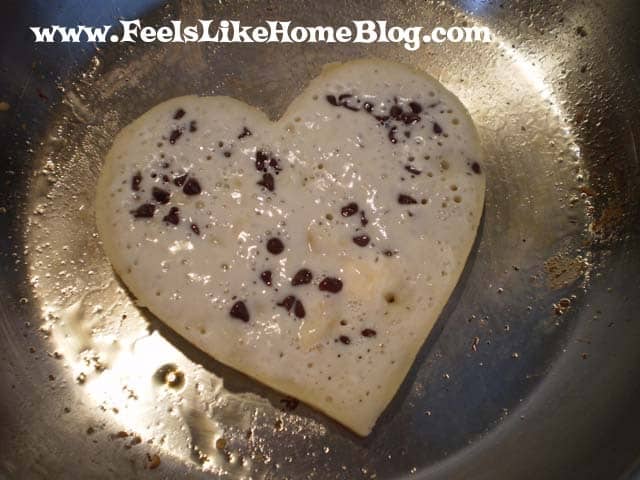 A pancake cooking with hearts