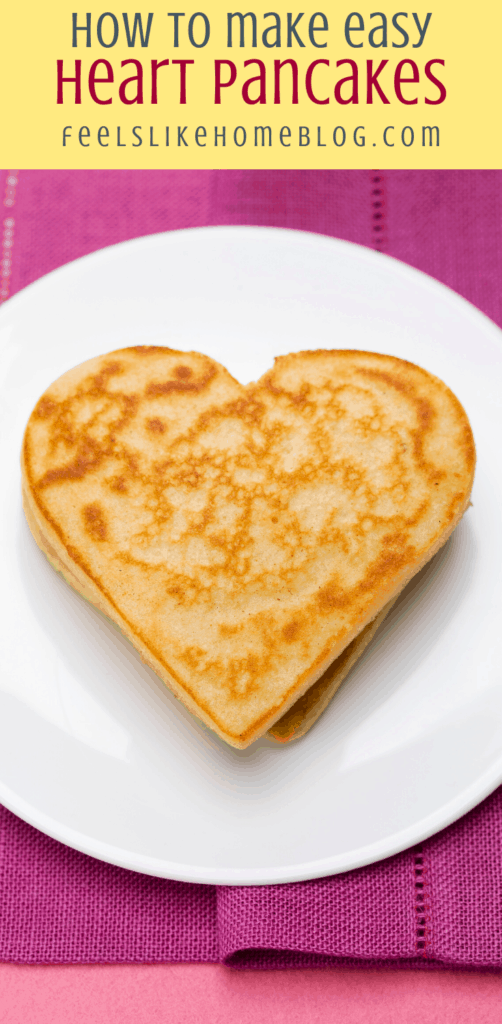 a pancake on a white plate with a pink napkin and hearts