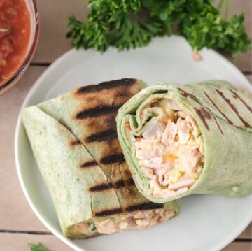 Make Ahead breakfast burritos all made and on a plate. cut in half to start enjoying