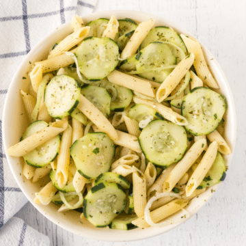 A bowl of pasta salad with cucumber slices
