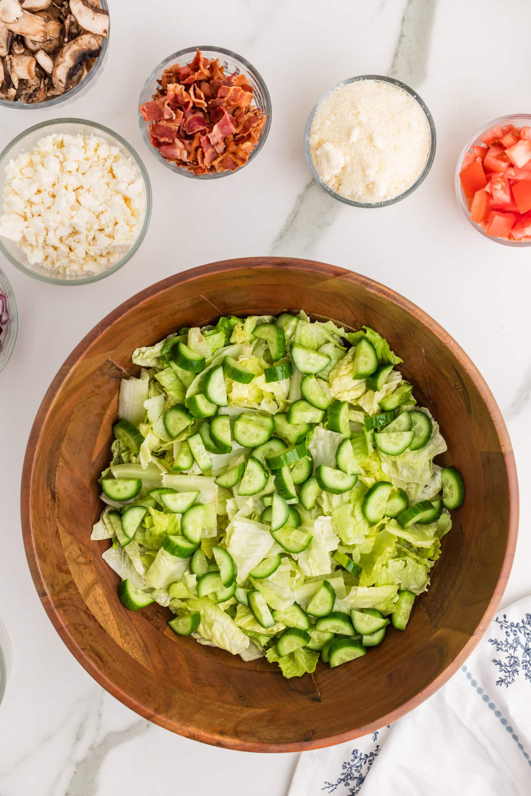 Chopped lettuce and cucumbers for Greek salad preparation