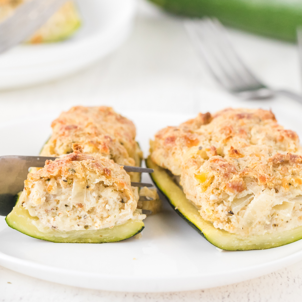 chicken and cheese stuffed zucchini on a white plate