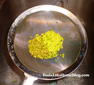 A strainer with dyed rice in it