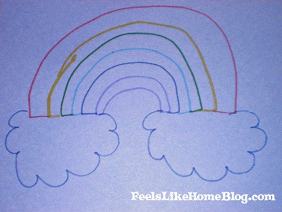 A close up of a rainbow drawn on blue paper