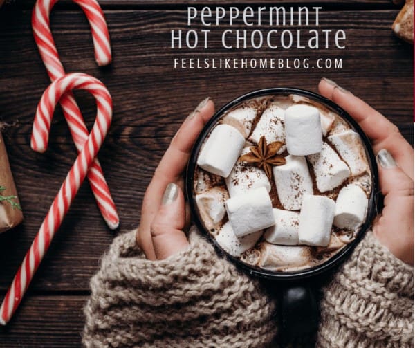 a mug of hot chocolate with marshmallows and candy canes and the title \"peppermint hot chocolate\"