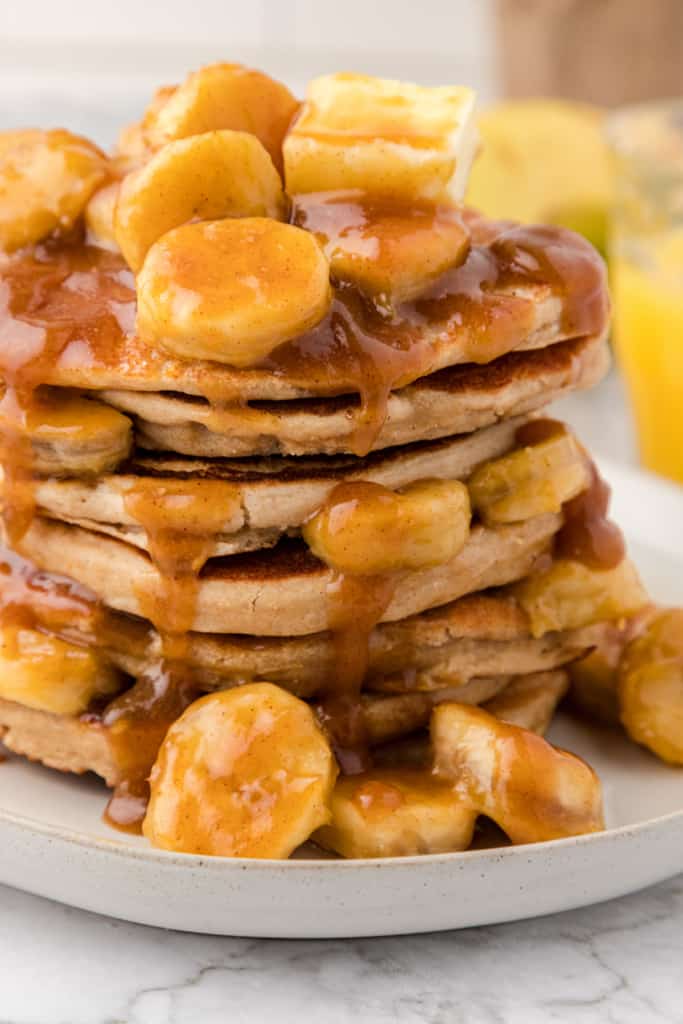 a stack pancakes topped with bananas foster sauce