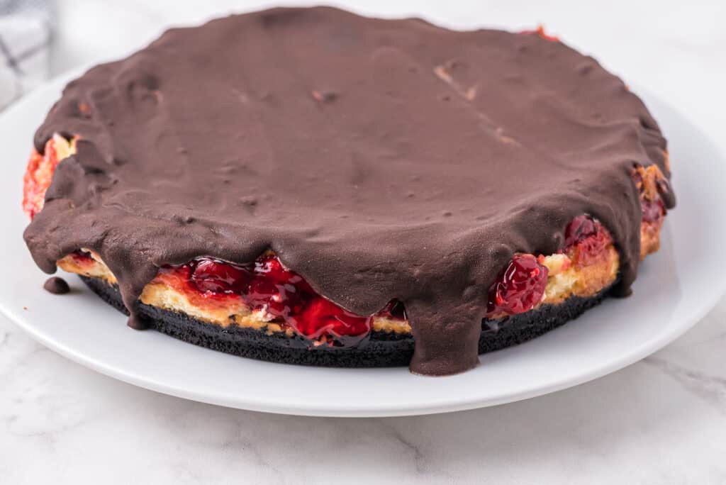 cooled chocolate cherry cheesecake covered in chocolate ganache