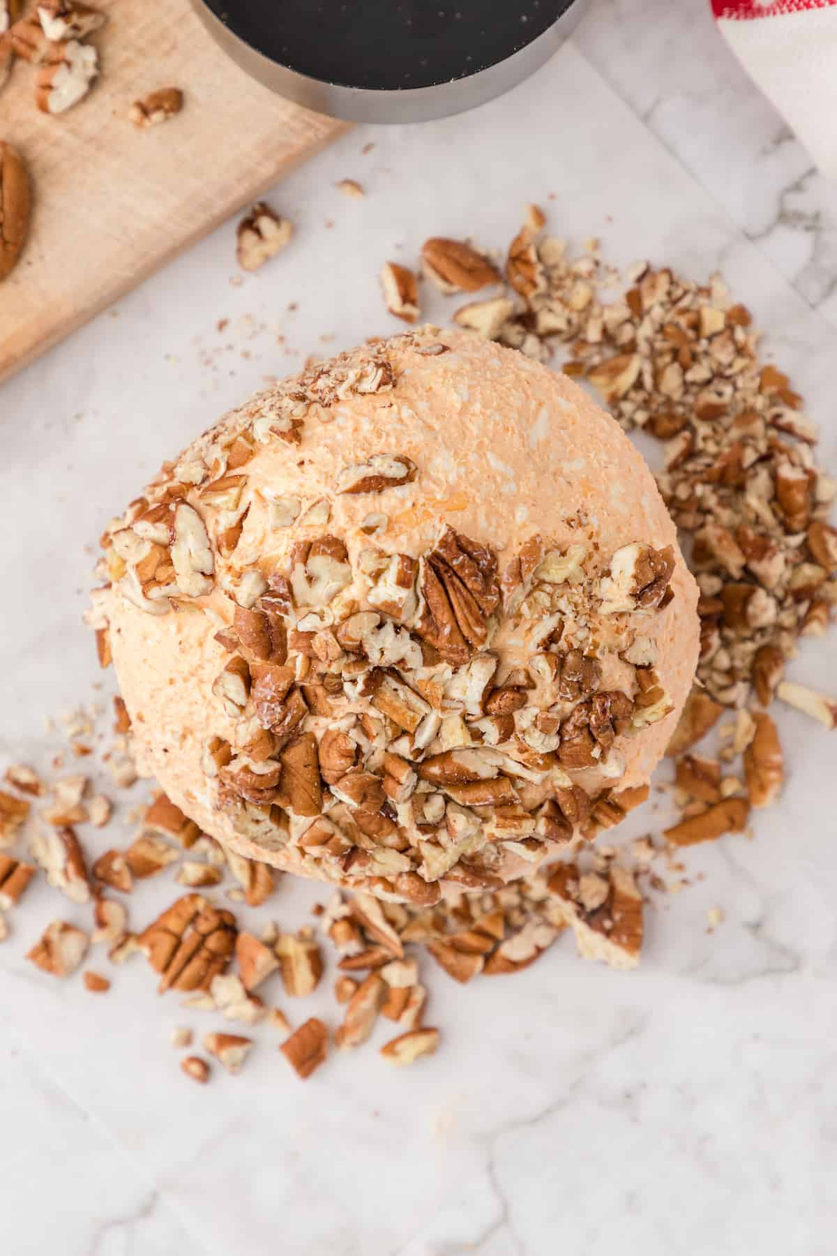 press chopped pecans into the surface of the cheese ball
