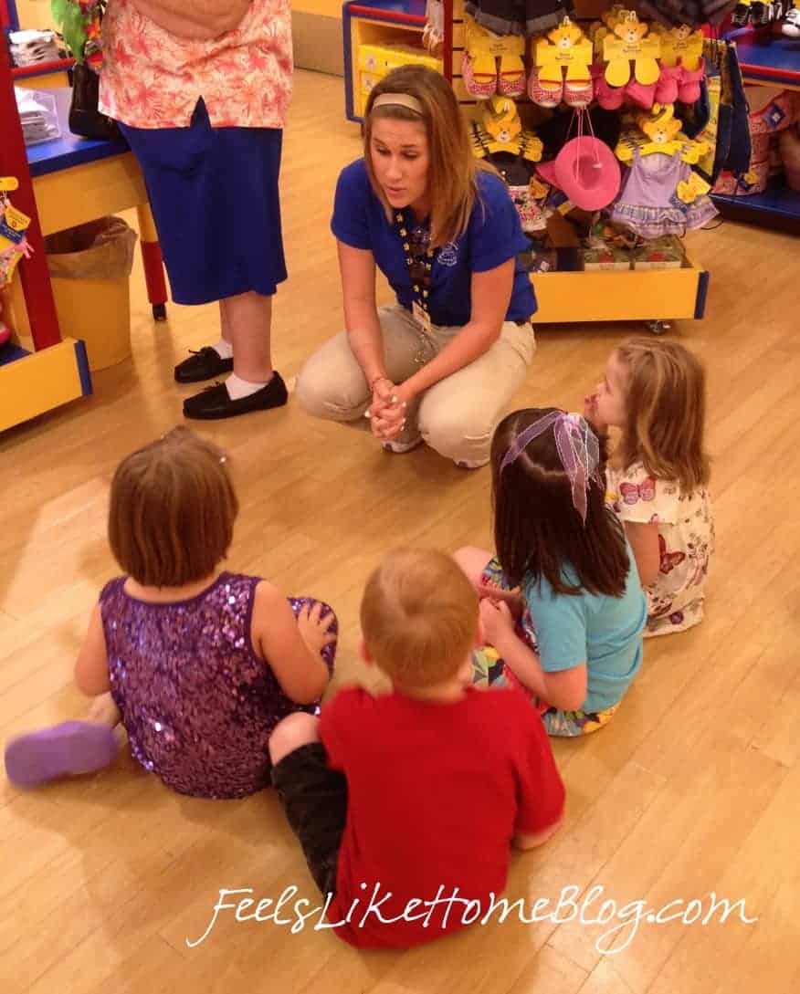 A group of young children sitting on the floor at Build A Bear Workshop
