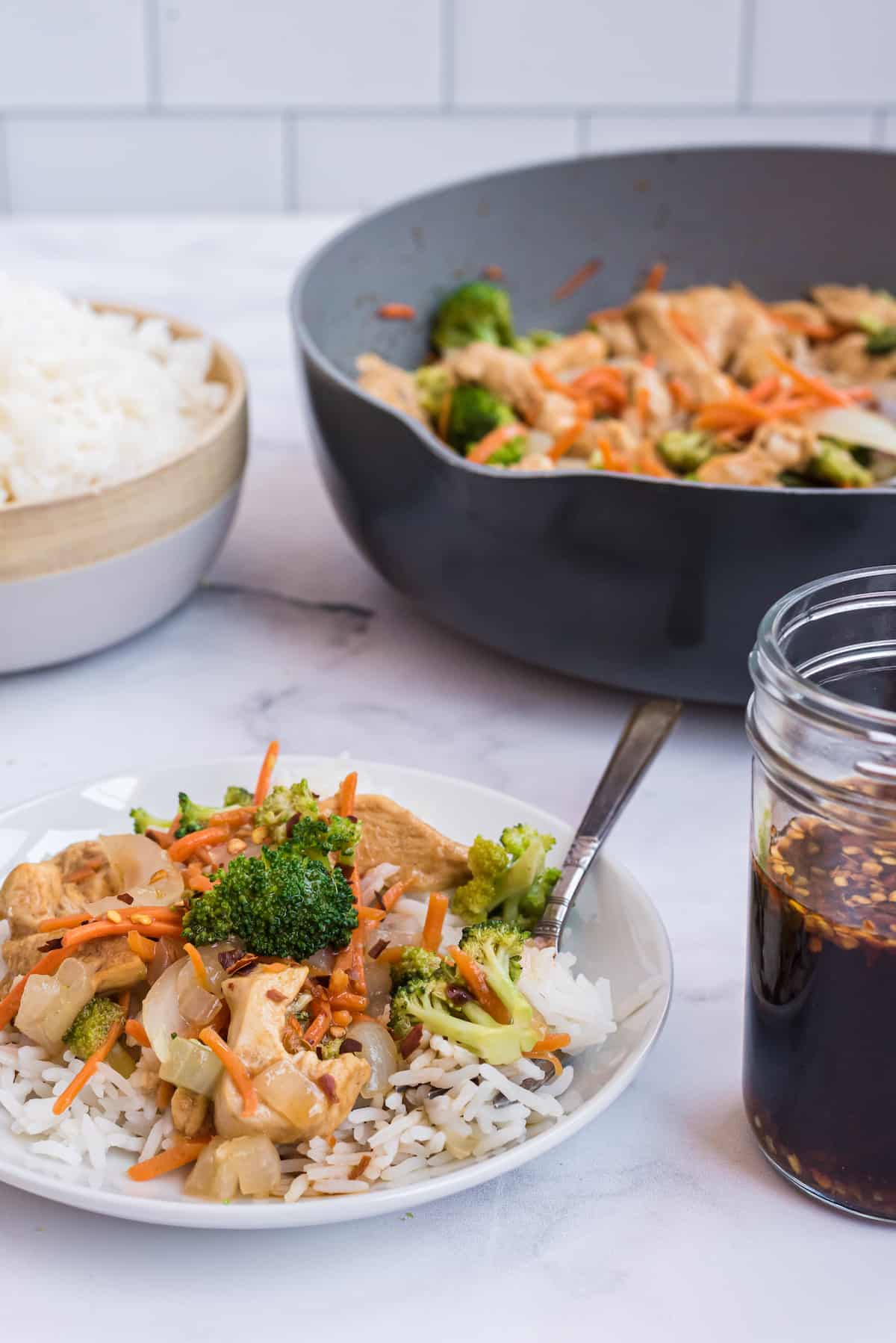 a plate of stir fry with a wok in the background