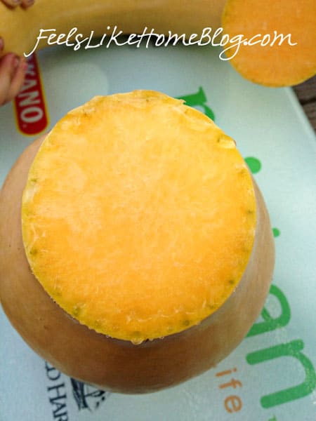 Two pumpkins sitting on top of a cutting board