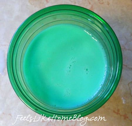 a green plastic cup full of green milk