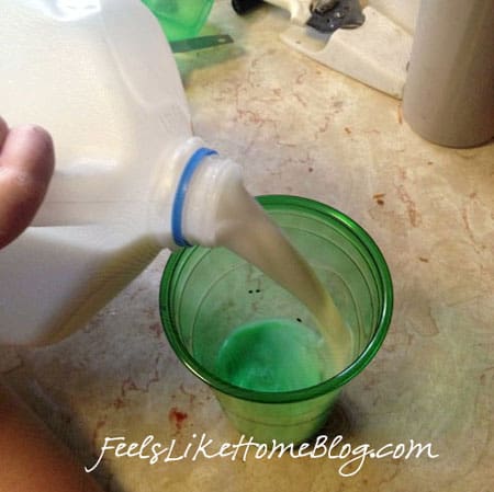 pouring milk into a green plastic cup