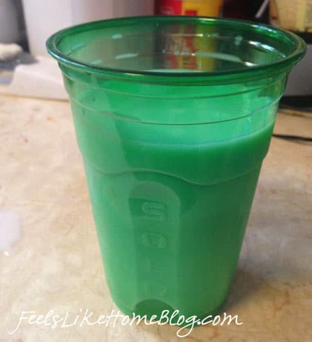 a green plastic cup of green milk