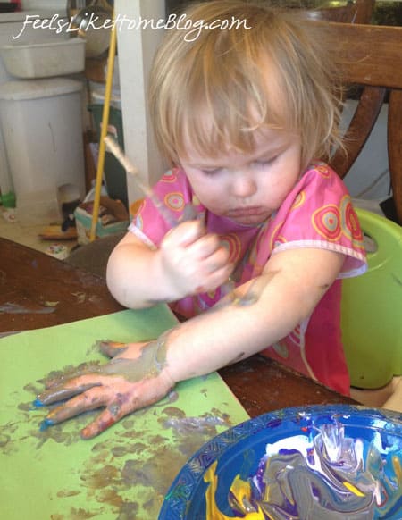 A little girl painting herself