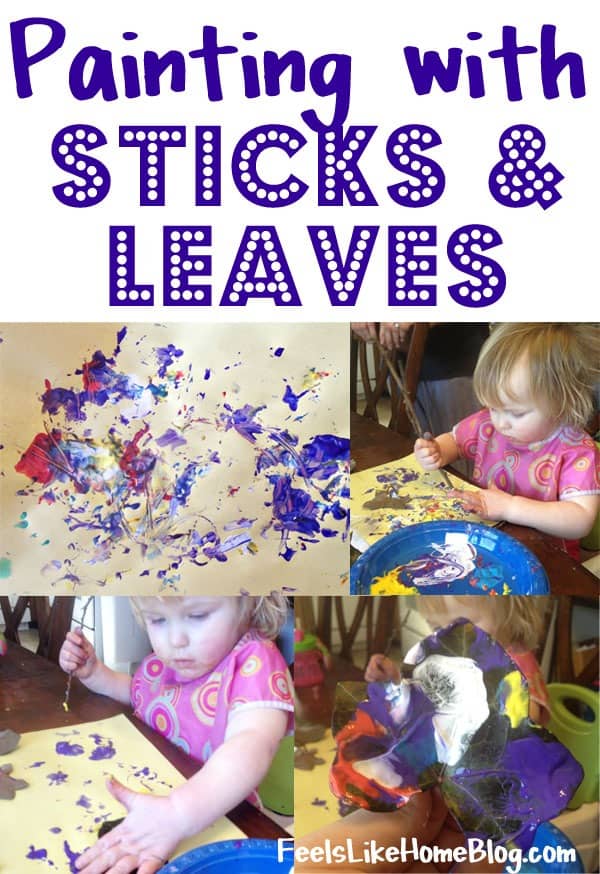 A little girl painting with sticks and leaves