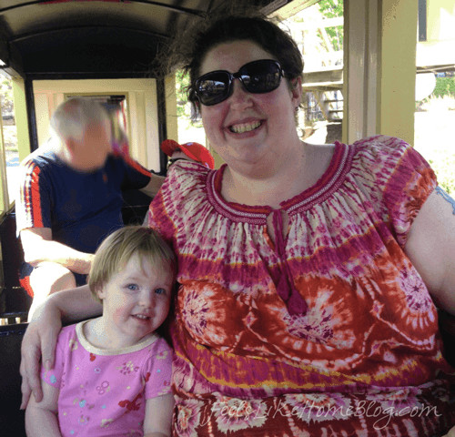 A woman and a little girl posing in a train car at Hersheypark