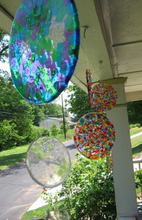 melted bead suncatchers hanging above a porch