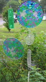 melted bead suncatchers hanging over a green bush