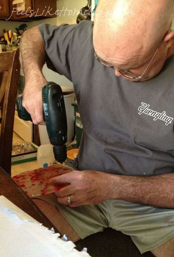 A man drilling a hole in the melted beads