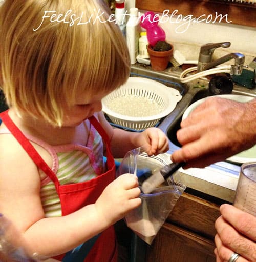 A little girl holding a bag of pudding mix