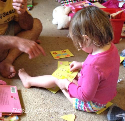 a little girl matching stickers on pages