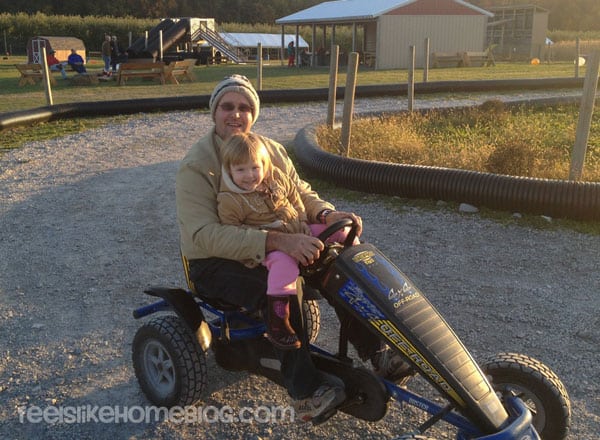 A dad and his daughter riding a go cart