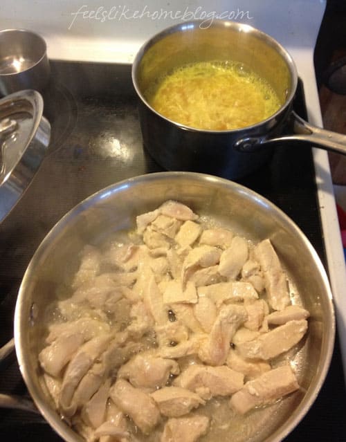 chicken cooking in a stainless steel skillet