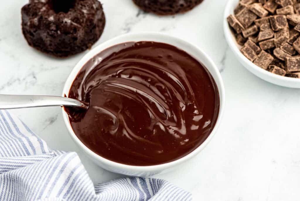 a small bowl of milk chocolate ganache with a spoon in it