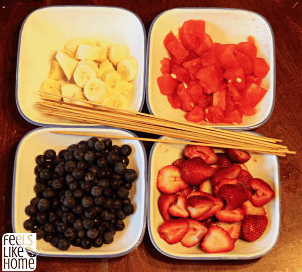 Bowls filled with banana, watermelon, blueberries, and strawberries