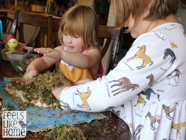 Young children adding moss to their island