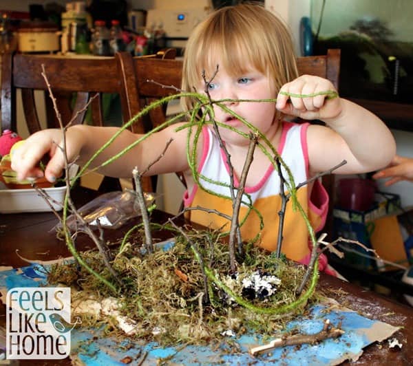 A small child adding vines to her island