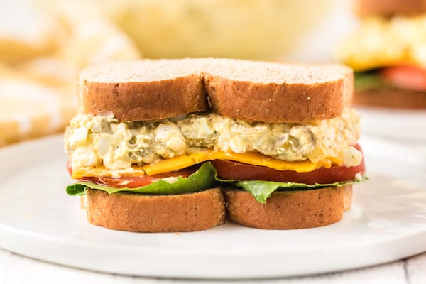 egg salad sandwich with lettuce, tomato, and cheese