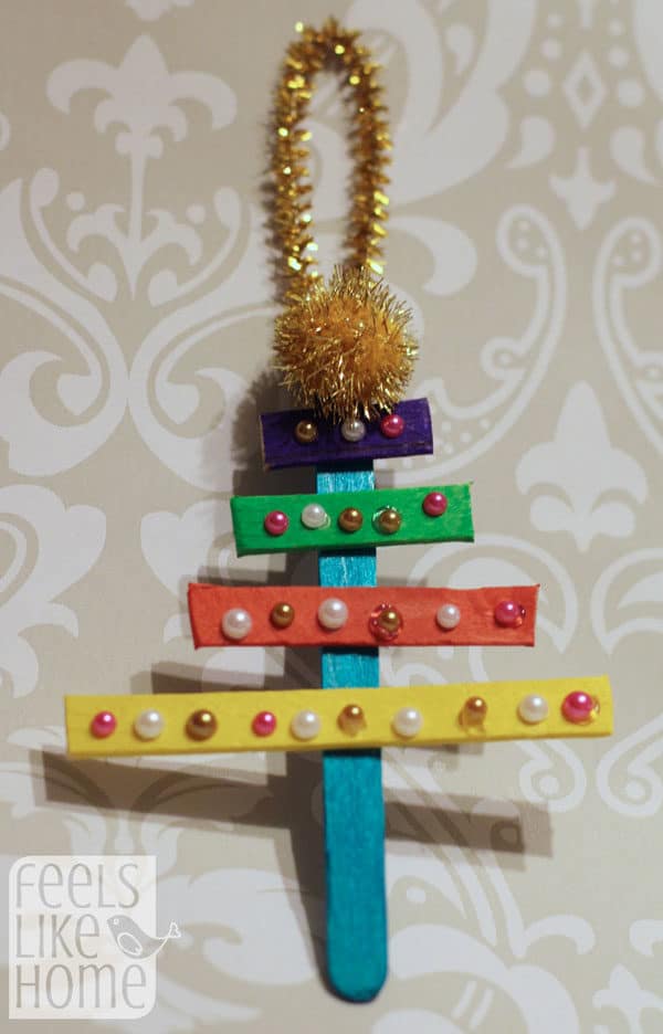 A Christmas tree ornament made from colored popsicle sticks