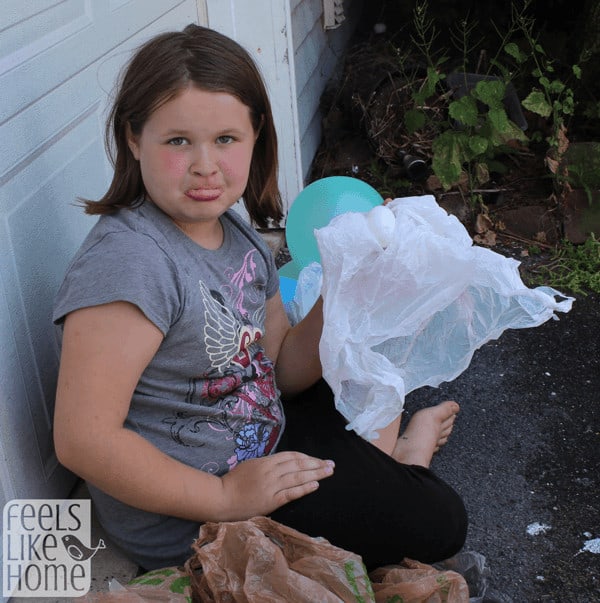 a little girl looking disappointed about her egg that\'s been unwrapped